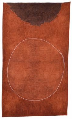 an orange and brown rug with a white circle on the top of it, in front of a white background