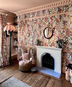 a living room with floral wallpaper and a fire place in the middle of the room