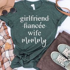 a t - shirt that says girlfriend fanee wife mommy on it next to some clothes