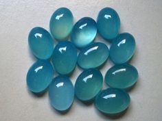 several blue glass pebbles on a white surface