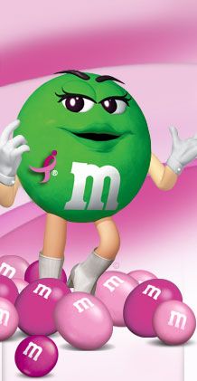 a green m & m's character riding on pink balls