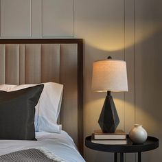 a bedroom with a bed, night stand and lamp