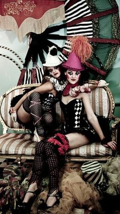 two women dressed in costumes sitting on a couch