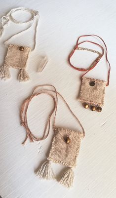 three different necklaces on a white table