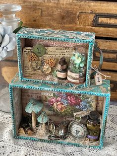 two boxes are stacked next to each other on a lace doily covered tablecloth