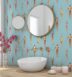 a bathroom with a sink, mirror and wallpaper that has different people on it