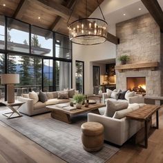 a living room filled with furniture and a fire place in front of a window overlooking the mountains