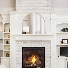 a living room with a fire place in the center and white furniture on the other side