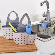 two kitchen utensils are sitting in a strainer on the counter next to a sink