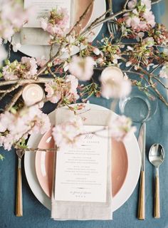 an instagram photo with pink flowers and candles on the table, next to silverware