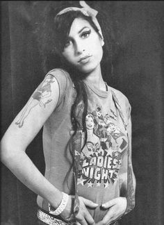 an old photo of a woman with tattoos on her arm