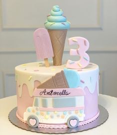 a birthday cake decorated with ice cream and an icecream cone is on a table