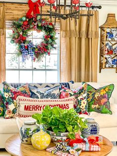 a living room filled with furniture and christmas wreaths on the window sill over a coffee table