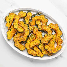 a white plate topped with squash covered in seasoning