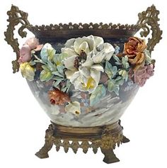 a vase with flowers in it sitting on a stand