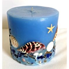 a blue candle with seashells and starfish on it