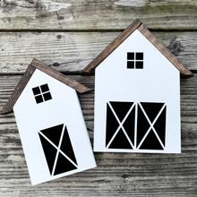 two wooden houses with black and white designs on them