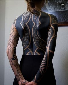 a woman with tattoos on her back and arms