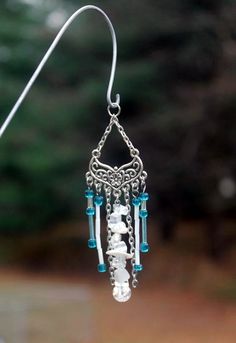 a pair of earrings with beads hanging from them