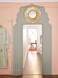 an open door leading to a hallway with pink walls