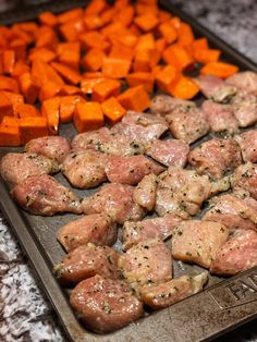 meat and veggies on a baking sheet ready to be cooked in the oven