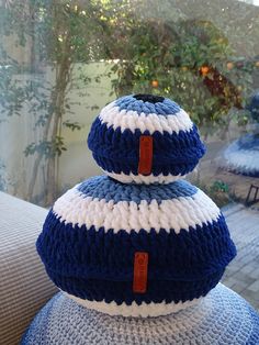 two blue and white knitted pillows stacked on top of each other