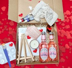 an open box filled with personal care items on a white bed covered in rose petals