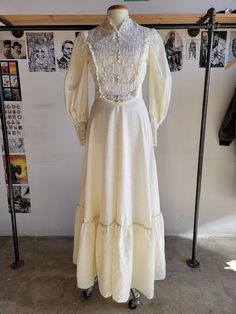 A victorian style 70s dress with large sleeves and a high collar. It has a lace bodice and a long sash. It's a romanic creamy white. It's in great condition, just one very faint stain on the bodice. Fits like size small. Shoulder - 14" Bust - 36" Waist - 26" Sleeve - 23.5" Length - 59" Lace Victorian Dress With Ruffles For Vintage Events, Victorian Vintage Lace Dress With Ruffles, Vintage Victorian Dress With Lace Trim For Costume, Spring Victorian Dress For Vintage Events In Regency Style, Spring Victorian Regency Dress For Vintage Events, Spring Regency Victorian Dress For Vintage Events, Victorian Vintage Costume Dress With Lace Trim, Spring Regency Style Victorian Dress For Vintage Events, Cream Cottagecore Victorian Wedding Dress