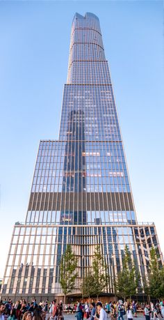 people are standing outside in front of a tall building with many windows on the side