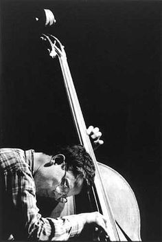 a black and white photo of a man holding a bass