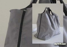 a gray purse with black zippers on it