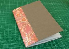 an open notebook sitting on top of a green cutting board