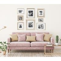 a living room with pink couches and pictures on the wall above them, along with potted plants