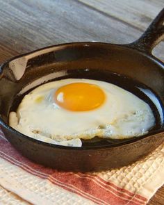 an egg frying in a skillet on top of a towel