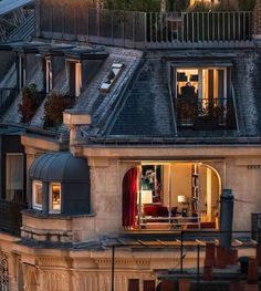 an apartment building is lit up at night with lights on the windows and balconies