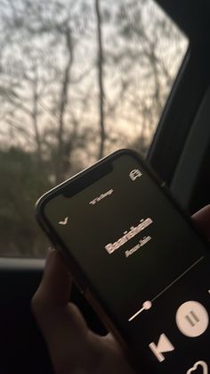 a person holding a cell phone in their hand while sitting in a car with the window open