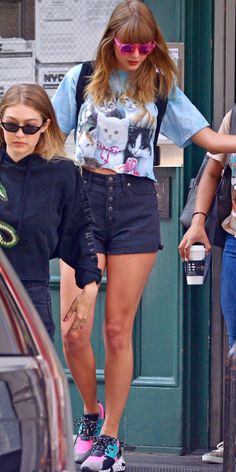 two women walking down the street with one holding her hand out to another woman's shoulder