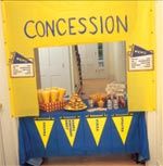 a yellow and blue concession booth set up with food on the table in front of it