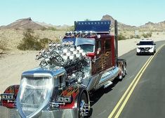 a large semi truck driving down the road with an engine on it's side