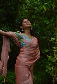 a woman is standing in the woods with her arms out and looking up at something