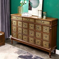 a wooden dresser sitting in front of a green wall