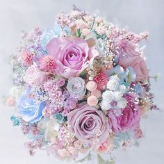 a bridal bouquet with pink, blue and white flowers is shown in this image