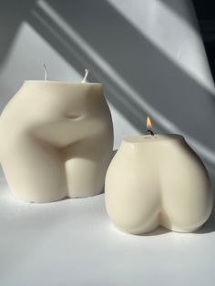 a candle that is shaped like a human head and sitting next to it on a table