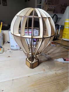 a hot air balloon sitting on top of a wooden table next to a pencil holder