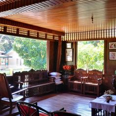 a living room filled with wooden furniture and lots of windows