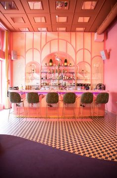 the bar is decorated with pink walls and black and white checkered flooring