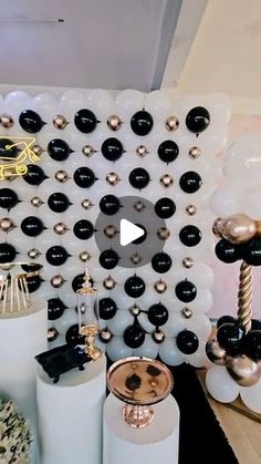 there are many balloons and other decorations on the wall in this living room that is decorated with black and white balls