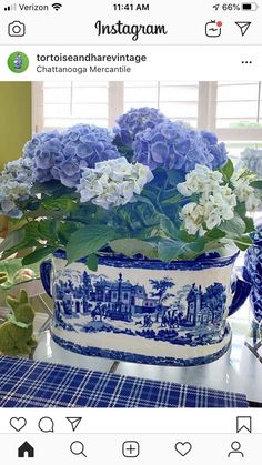 a blue and white flower pot sitting on top of a table