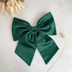 Large and pretty green hair bow. Made from sturdy duchess satin.   This oversized hair bow is an ideal hair accessory for wearing to a special occasion or even everyday wear. 🎁 This will also make a great "gift for girl." ✂️ They are handmade with love and care from  high quality fabric in our studio in England. 📏 The bow measurement.. 8" in width appx  12 cm or 4 3/4" in height  Tail is 18 cm or 6 1/2" - 7" long appx (measured excluding the bow) 📍Attachment:  ✅Barrette ✅Comb slide  ✅Brooch pin 🧷  📝 If you are not sure whether this bow will match with the colour of your dress, please message us in order to get a fabric swatch first to see the colour in person. *Please be noted that the colour might appear a little differently on each phone, tablet, or computer screen. Green Bow Hair Clip, Emerald Hair Bow, Pretty Green Hair, Forest Green Hair, Bow Wedding Hair, Bow Wedding, Hair Accessories For Girls, Duchess Satin, Bow Christmas