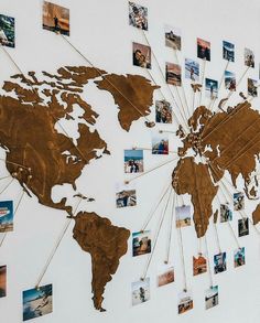 a world map is shown with many pictures pinned to it's sides and attached to the wall